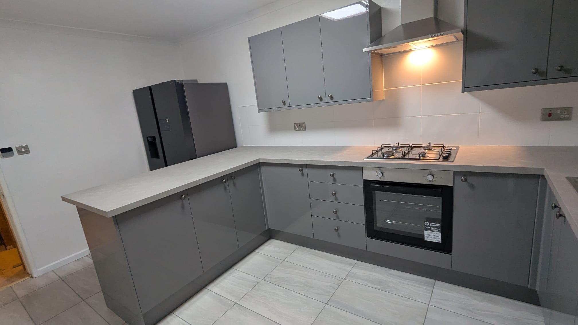 Modern grey gloss fitted kitchen with island, completed by Home Improvement in Cornwall